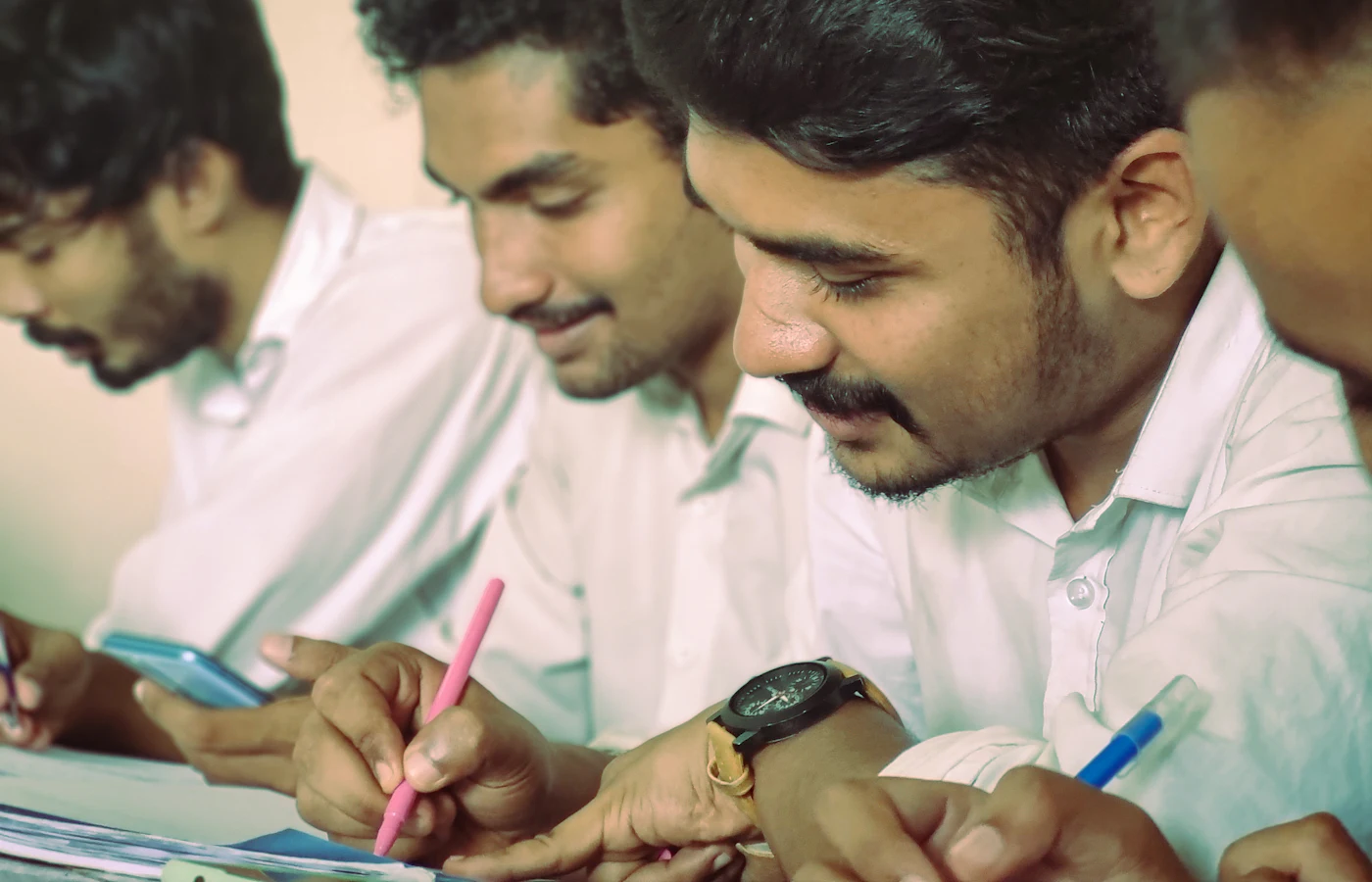 Three students sketching an idea together on paper